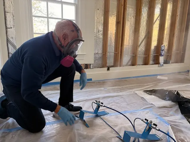 A restoration technician setting drying equipment in an Aurora home stripped to the studs